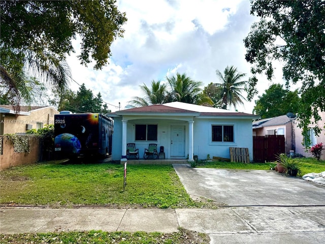 ranch-style house featuring covered porch and a front lawn