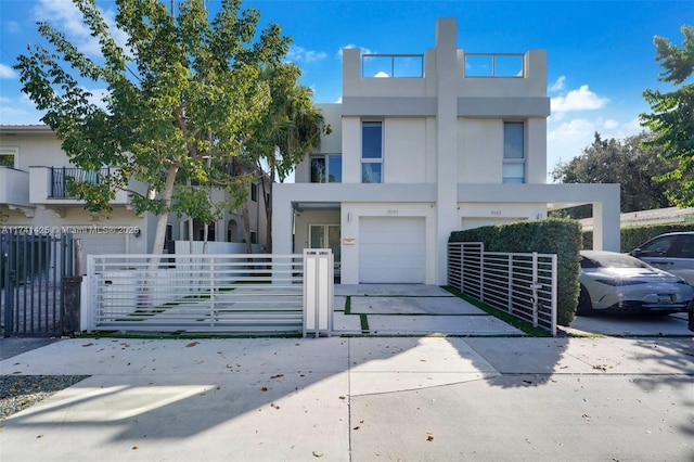 view of front of house featuring a garage, driveway, a fenced front yard, and stucco siding