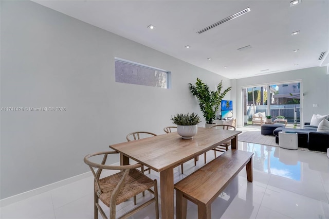 dining space featuring light tile patterned floors, visible vents, and baseboards