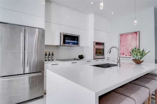 kitchen featuring an island with sink, modern cabinets, stainless steel appliances, and light countertops