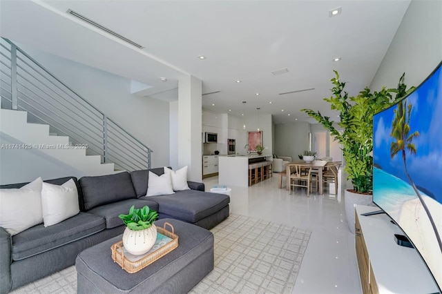 living area with recessed lighting, visible vents, and stairs