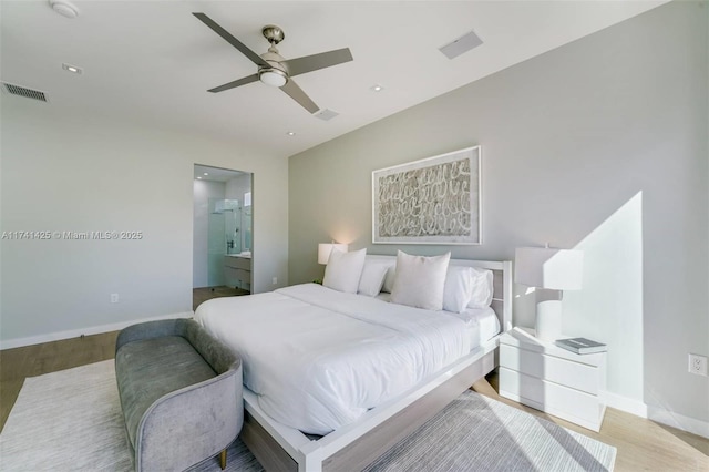 bedroom with visible vents, ensuite bath, light wood finished floors, and baseboards