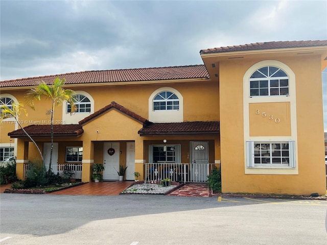 mediterranean / spanish-style house with covered porch