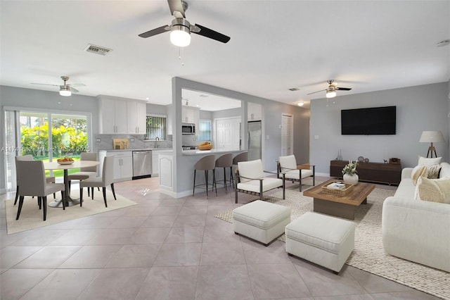 tiled living room featuring sink and ceiling fan