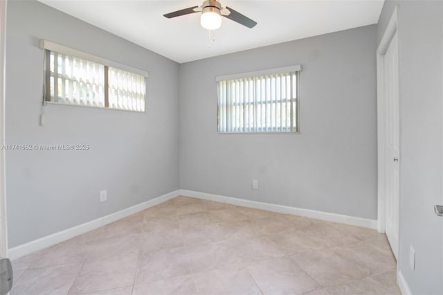 tiled spare room with a healthy amount of sunlight and ceiling fan