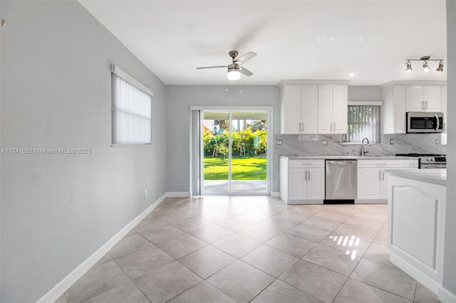 kitchen with white cabinets, sink, stainless steel appliances, and decorative backsplash