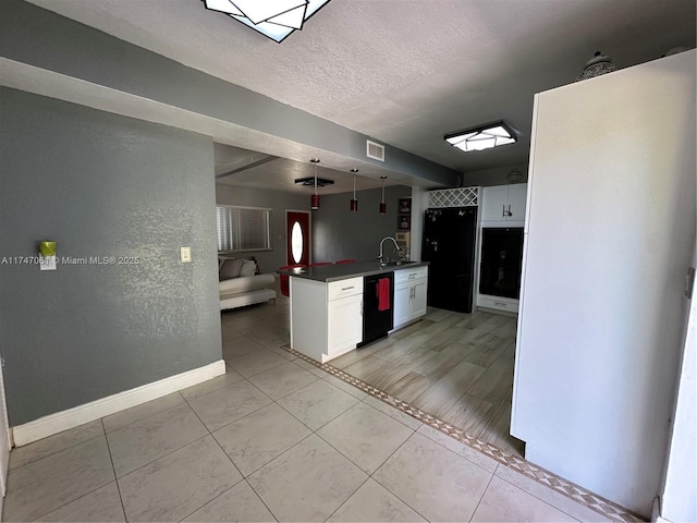 kitchen featuring kitchen peninsula, hanging light fixtures, black appliances, sink, and white cabinets