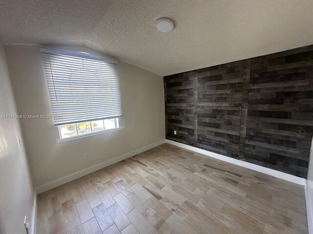 13926 SW 164th St, Miami, FL 33177 - unfurnished room featuring lofted ceiling, wood finished floors, a textured ceiling, and baseboards