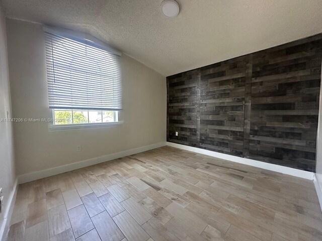 13926 SW 164th St, Miami, FL 33177 - unfurnished room with a textured ceiling, wood finished floors, vaulted ceiling, and baseboards