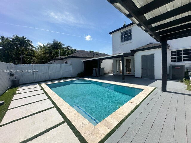 13926 SW 164th St, Miami, FL 33177 - view of swimming pool featuring central AC unit, a fenced backyard, a wooden deck, and a patio