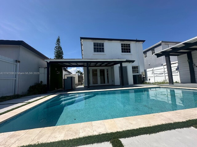 13926 SW 164th St, Miami, FL 33177 - view of swimming pool featuring french doors, central AC, and fence