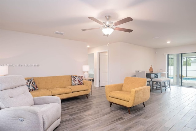 living area featuring a ceiling fan, visible vents, wood finished floors, and recessed lighting