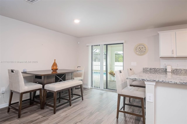 dining room featuring light wood-style floors, baseboards, and recessed lighting