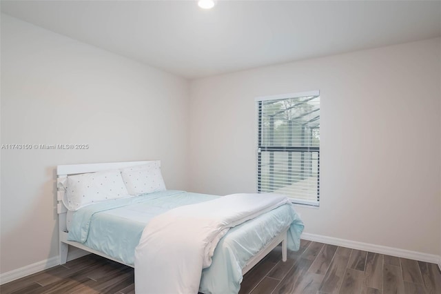 bedroom featuring baseboards and wood finished floors