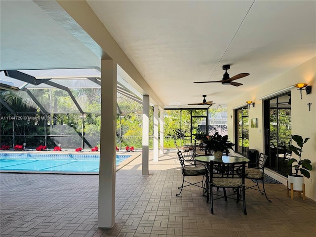 view of patio featuring ceiling fan and glass enclosure