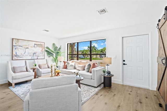 living room with light hardwood / wood-style flooring and a barn door