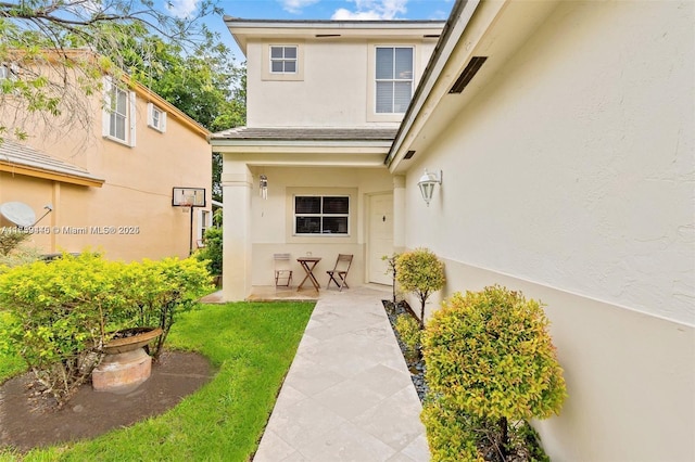 doorway to property featuring stucco siding