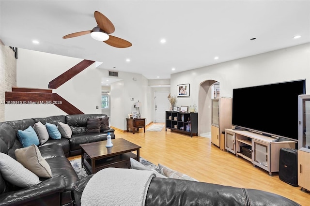 living room featuring baseboards, visible vents, recessed lighting, arched walkways, and light wood-type flooring