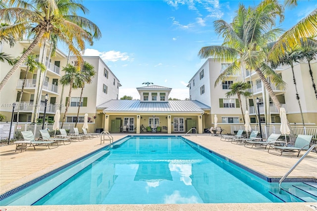 community pool featuring a patio, french doors, and fence