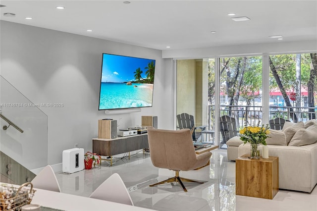 living area with recessed lighting and marble finish floor