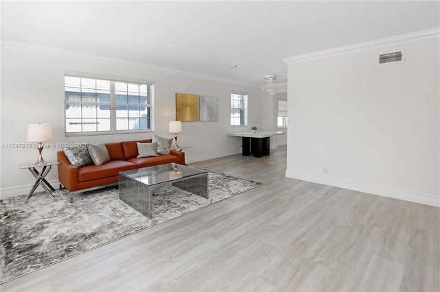 living area featuring baseboards, visible vents, crown molding, and light wood finished floors