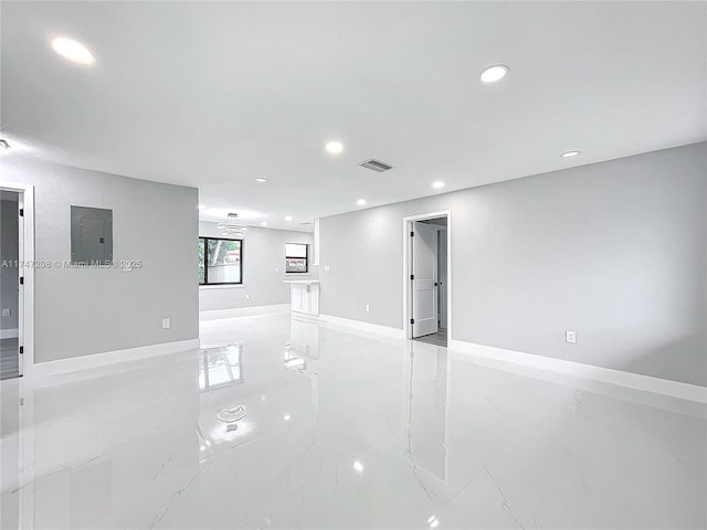 unfurnished room with marble finish floor, recessed lighting, visible vents, electric panel, and baseboards