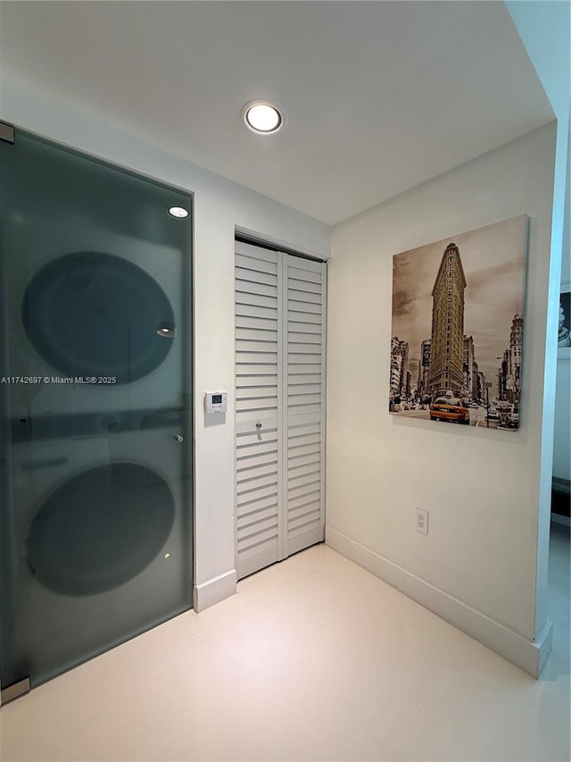 washroom featuring stacked washer and clothes dryer