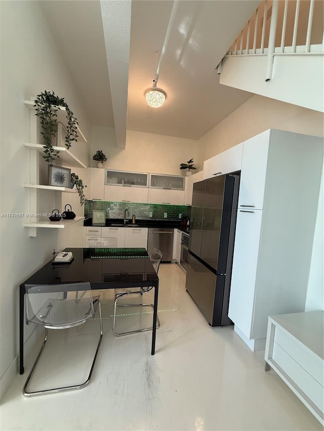 kitchen with decorative backsplash, sink, stainless steel appliances, and white cabinets