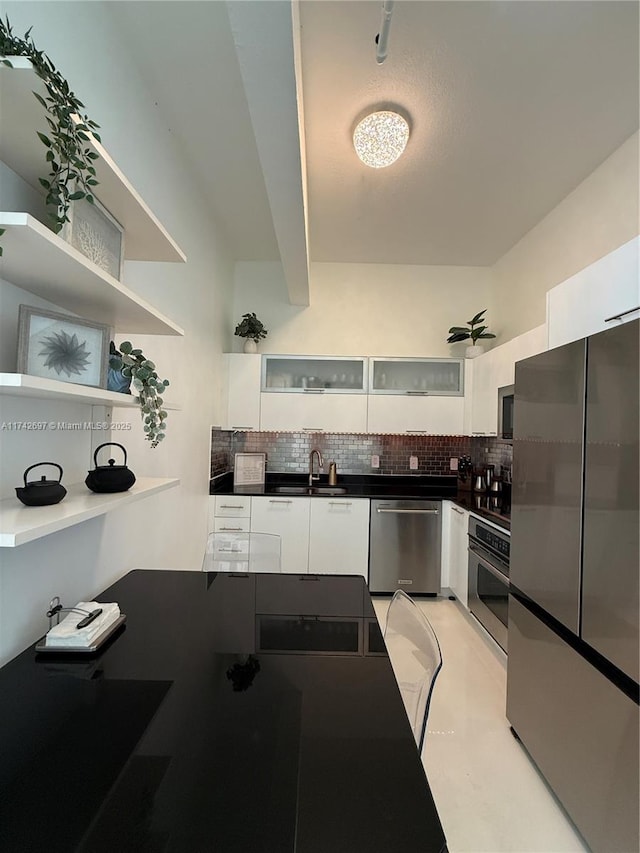 kitchen featuring sink, backsplash, white cabinets, and stainless steel appliances