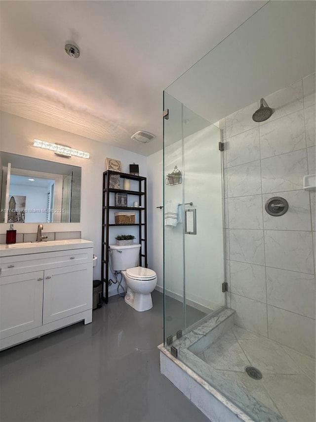 bathroom with toilet, vanity, and an enclosed shower