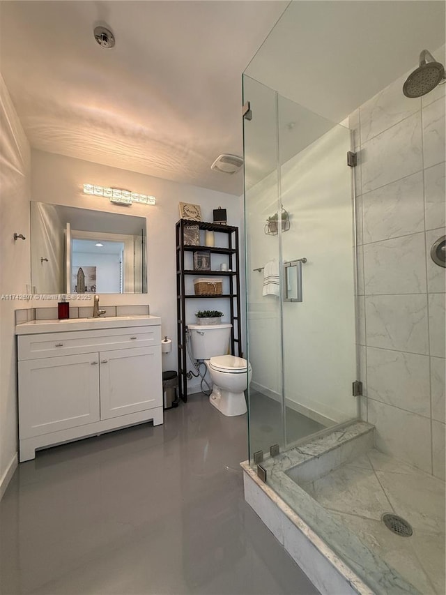 bathroom with toilet, vanity, and an enclosed shower