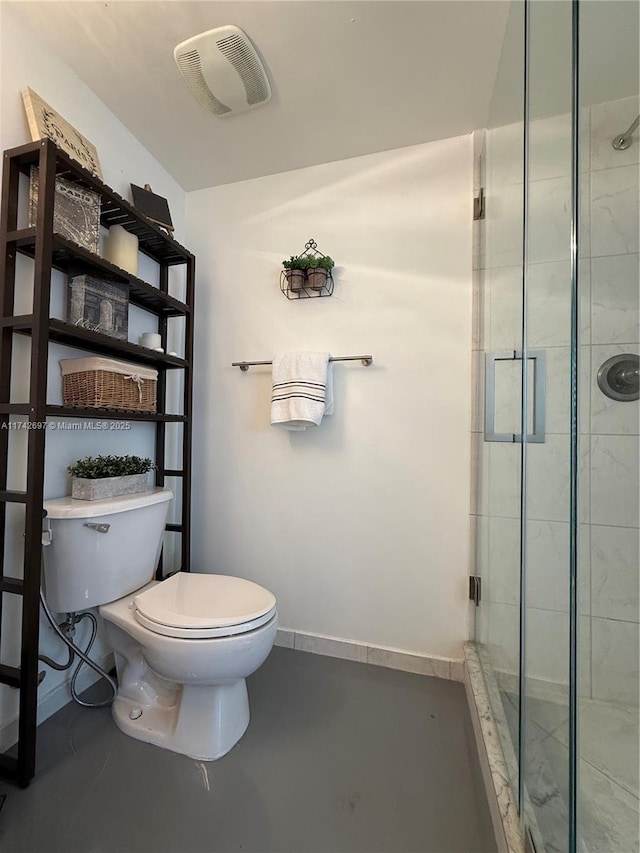 bathroom with toilet, a shower with shower door, and concrete floors