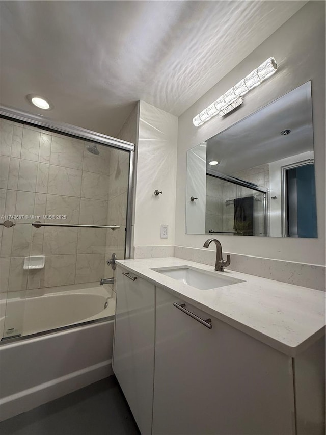 bathroom featuring enclosed tub / shower combo and vanity