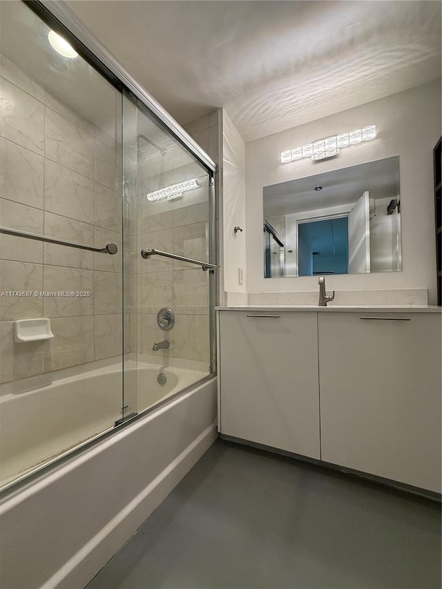 bathroom with vanity, bath / shower combo with glass door, and concrete floors