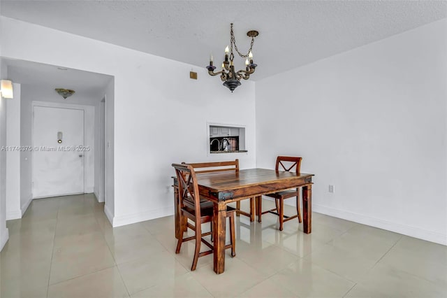 tiled dining area featuring an inviting chandelier and a textured ceiling
