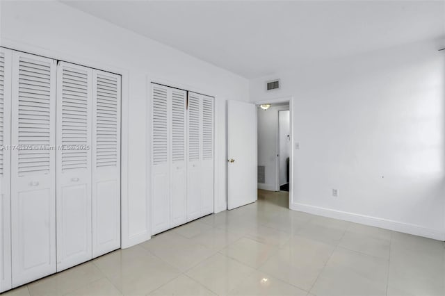 unfurnished bedroom featuring multiple closets