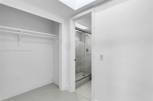 bathroom with a skylight and a shower with door