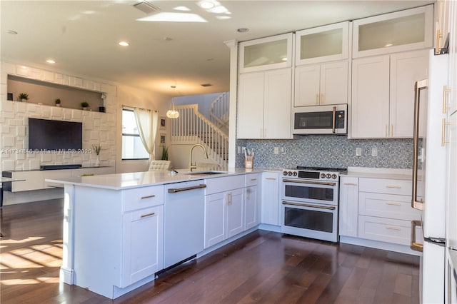 kitchen with sink, white cabinetry, white dishwasher, kitchen peninsula, and range with two ovens