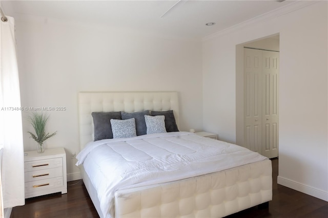 bedroom featuring crown molding, dark hardwood / wood-style floors, and a closet