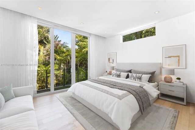 335 W 46th St, Miami Beach, FL 33140 - bedroom featuring a wall of windows, multiple windows, access to outside, and light wood-type flooring