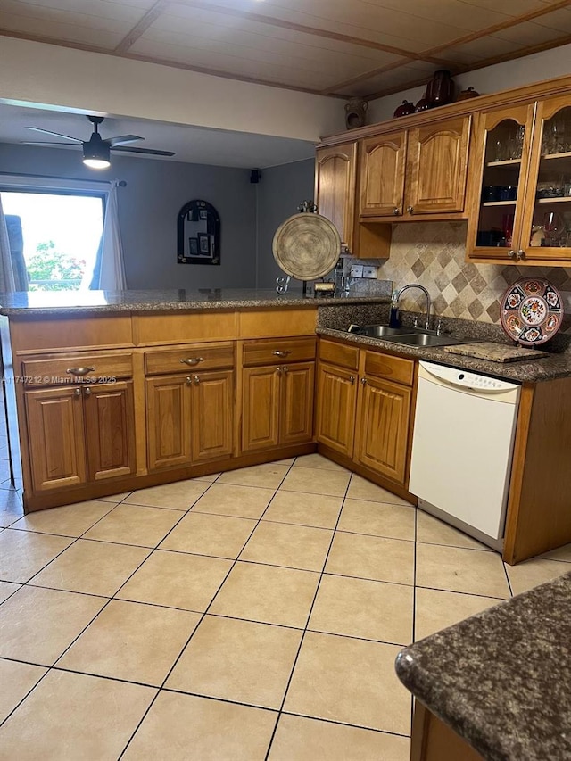 kitchen featuring light tile patterned floors, sink, backsplash, ceiling fan, and white dishwasher