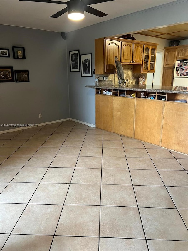 kitchen featuring backsplash, white refrigerator, ceiling fan, and light tile patterned floors