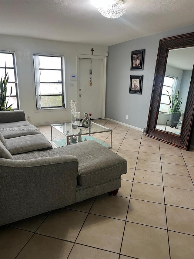 living room featuring light tile patterned floors, a textured ceiling, and a healthy amount of sunlight