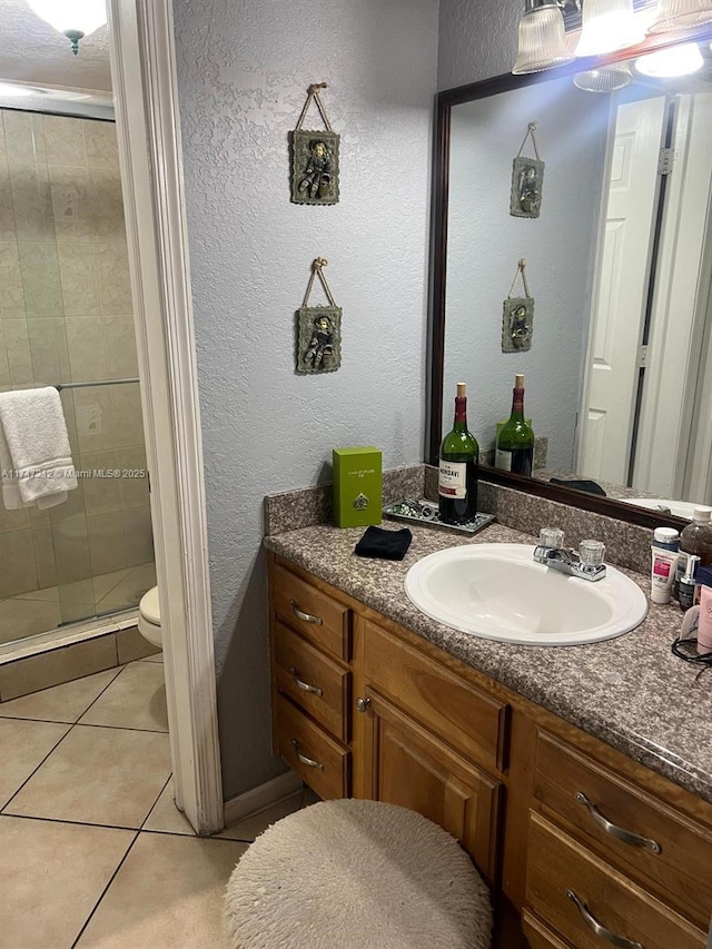 bathroom featuring vanity, an enclosed shower, toilet, and tile patterned floors