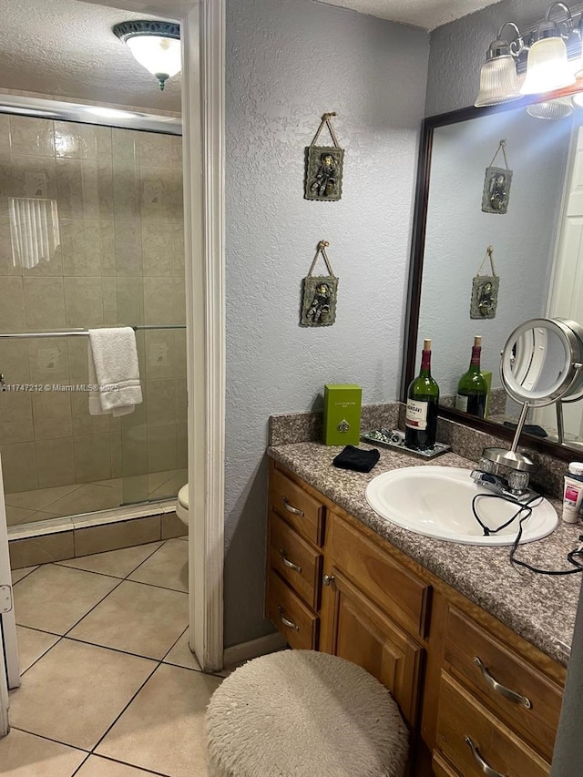 bathroom featuring vanity, toilet, tile patterned floors, and walk in shower