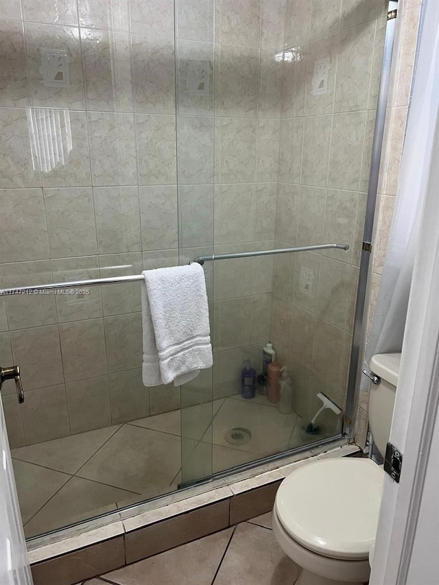 bathroom with toilet, tile patterned floors, and walk in shower