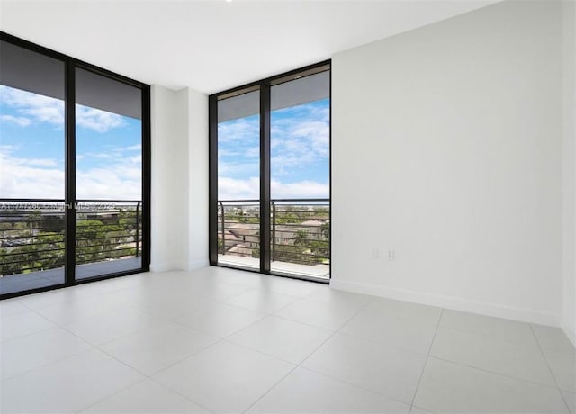 unfurnished room featuring floor to ceiling windows, baseboards, and tile patterned flooring