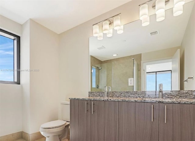 full bathroom with toilet, a shower stall, double vanity, and baseboards
