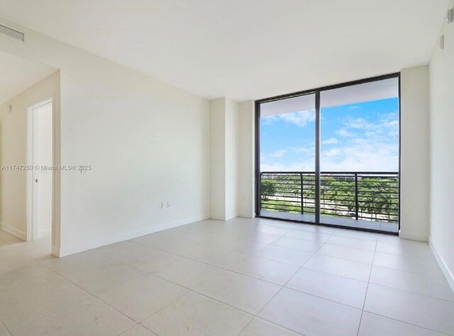 spare room featuring light tile patterned floors and floor to ceiling windows