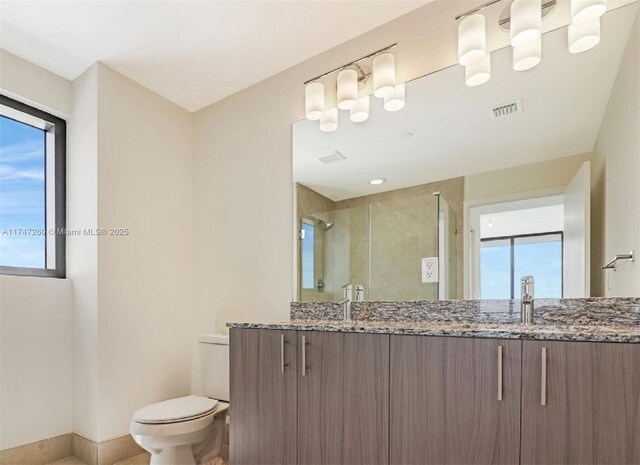 bathroom with toilet, vanity, and an enclosed shower